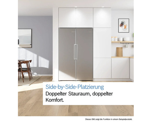 Side-by-Side Kühlschrank aus Edelstahl in einer modernen, hellen Küche mit weißen Schränken und hellem Holzboden.