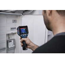 Person prüft eine elektrische Installation im Verteilerkasten mit einer Bosch Wärmebildkamera.