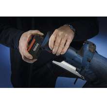 Eine Person setzt einen Akku aus dem Bosch Professional 18 Volt System in eine Stichsäge ein.