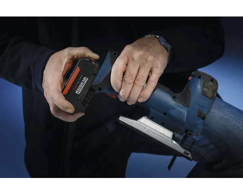 Eine Person setzt einen Akku aus dem Bosch Professional 18 Volt System in eine Stichsäge ein.