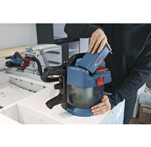 Eine Person setzt einen 18 Volt Akku in einen Bosch Professional Akku-Staubsauger GAS 18 Volt-1 in einer Werkstatt ein.