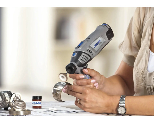 Eine Person verwendet ein Dremel 8100 Akku-Multitool mit Polierzubehör zum Polieren eines Armreifs aus Metall.