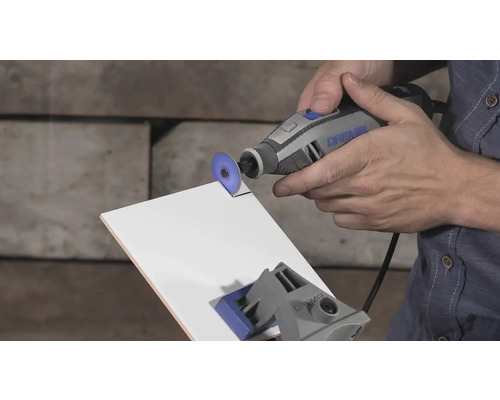 Dremel Multifunktionswerkzeug beim Schneiden einer weißen Fliese mit einer Trennscheibe.