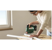 Person mit Schutzbrille schneidet mit einer Bosch Akku-Stichsäge ein weißes Kunststoffprofil auf einer Werkbank.