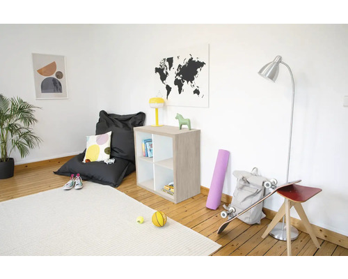 Helles Zimmer mit Sitzsack, Holzregal, Stehlampe und Teppich auf Holzboden. Modern und übersichtlich eingerichtet.