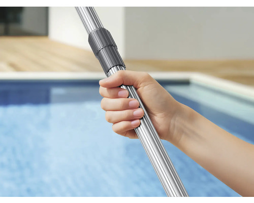 Eine Hand hält eine ausziehbare Teleskopstange aus Aluminium für die Poolreinigung mit Drehverschluss über dem Wasser.