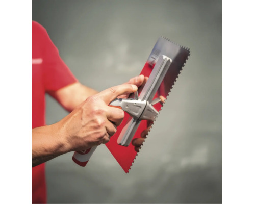Eine Person hält eine Zahnkelle aus Edelstahl mit einem ergonomischen Griff.