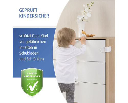 Ein Kleinkind steht neben einer Kommode, die mit einer geprüften Kindersicherung für Schubladen und Schränke gesichert ist.