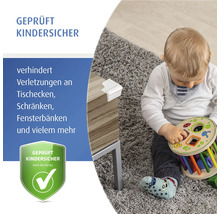 Weißer Eckenschutz an einer Tischkante aus Holz mit einem spielenden Kleinkind, zur Illustration der geprüften Kindersicherheit.