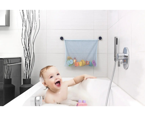 Blaues Badewannen-Spielzeugnetz mit Saugnäpfen an weißen Fliesen über einem Kind in einer Badewanne mit Badeschaum.