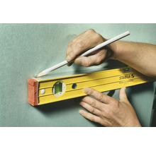 Stabila Wasserwaage wird zum Anzeichnen einer geraden Linie mit einem Bleistift an einer Wand verwendet.