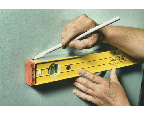 Stabila Wasserwaage wird zum Anzeichnen einer geraden Linie mit einem Bleistift an einer Wand verwendet.