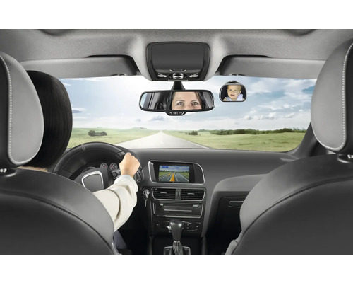 Heller Innenraum eines modernen Autos mit zusätzlichem Sicherheitsspiegel für Babys an der Windschutzscheibe, der ein Kind auf dem Rücksitz zeigt.