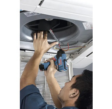 Eine Person nutzt einen Bosch Akku-Schlagschrauber zur Montage oder Reparatur einer Deckenklimaanlage.