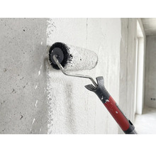 Rautner Farbroller trägt Farbe auf eine strukturierte Betonwand auf.