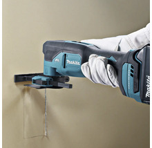 Makita Akkumulator-Multifunktionswerkzeug beim Schneiden einer rechteckigen Öffnung in eine Wand.