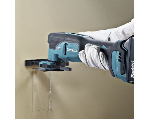 Makita Akkumulator-Multifunktionswerkzeug beim Schneiden einer rechteckigen Öffnung in eine Wand.