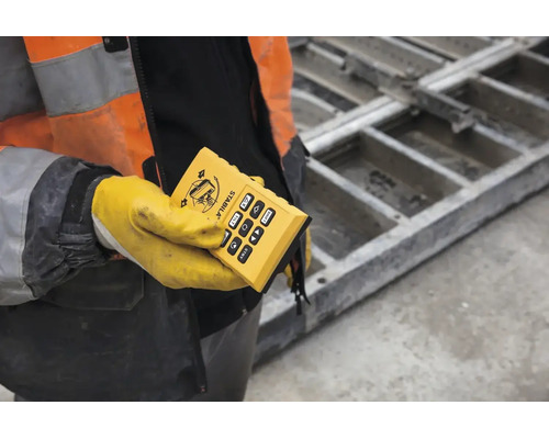 Stabila Fernbedienung für Baulaser, gehalten von einer Person in Schutzkleidung auf einer Baustelle.