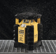 Stabila LAR 350 Rotationslaser in spritzwassergeschützter Ausführung auf einem Metallgitter unter fallenden Wassertropfen.