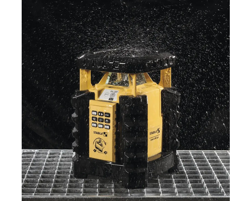 Stabila LAR 350 Rotationslaser in spritzwassergeschützter Ausführung auf einem Metallgitter unter fallenden Wassertropfen.