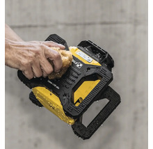 Eine Hand reinigt den wasserfesten Stabila Rotationslaser LAR 160 mit einem Schwamm vor einer Betonwand.