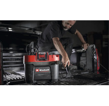 Person reinigt die Ladefläche eines Pickups mit einem Einhell Professional Akku Nass Trockensauger.
