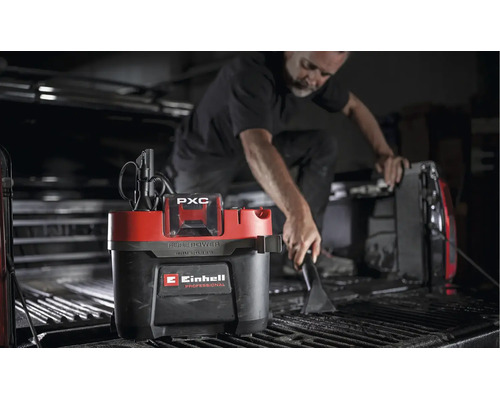 Person reinigt die Ladefläche eines Pickups mit einem Einhell Professional Akku Nass Trockensauger.