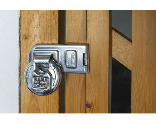 ABUS Diskus Zahlenschloss mit vier Ziffern an einer Überfalle aus Metall auf einem Holztor.