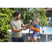 Mann pumpt Schwimmflügel eines Kindes mit einer Akku-Luftpumpe an einem Gartenpool auf.