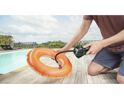 Eine Person verwendet eine Bosch Akku-Druckluftpumpe, um einen orangefarbenen Schwimmreifen an einem Pool aufzupumpen.