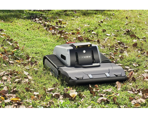 Lymow Mähroboter mit Kettenantrieb und Sensoren auf einer Rasenfläche mit braunem Laub in hellem Tageslicht.