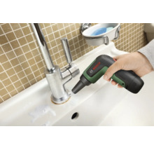 Eine Hand führt die Bosch UniversalBrush Akku-Reinigungsbürste am Sockel einer verchromten Waschbeckenarmatur entlang.