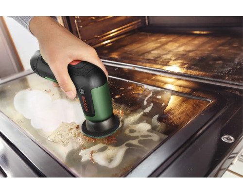 Bosch Akku-Reinigungsbürste UniversalBrush reinigt eine verschmutzte Backofentür mit Reinigungsschaum.