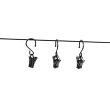 Drei schwarze Gardinenklammern mit Haken aus Metall, aufgehängt an einer dünnen Stange.