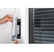Einbau eines Gurtwicklers für Rollläden in die Wand neben einem Fenster mit geschlossenem Rollladen.
