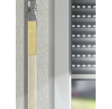 Rollladengurt-Reparaturset an einem Gurtband neben einem Fensterrahmen auf einer verputzten Wand.