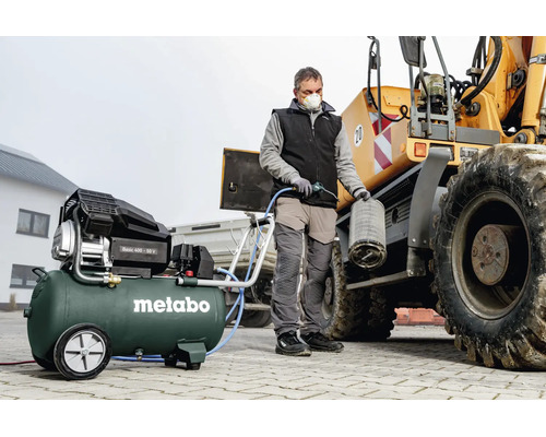 Person reinigt einen Luftfilter eines Baufahrzeugs mit einem Metabo Kompressor Basic 400-50 V.