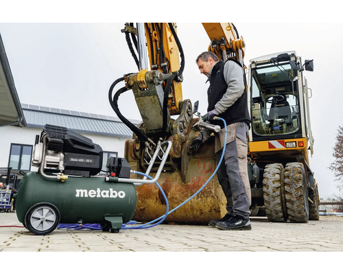 Metabo Kompressor Basic 400-50 V bei der Wartung eines Baggers mit einer Druckluft-Fettpresse.