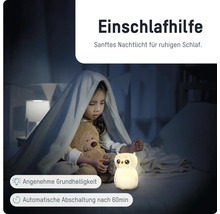 Kind im Bett mit Kuscheltier und leuchtendem Eulen-Nachtlicht als Einschlafhilfe mit automatischer Abschaltung nach 60 Minuten.