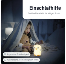 Kind im Bett mit Teddybär und leuchtendem Nachtlicht in Kükenform. Einschlafhilfe mit automatischer Abschaltung nach 60 Minuten.