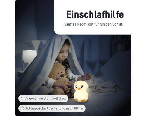 Kind im Bett mit Teddybär und leuchtendem Nachtlicht in Kükenform. Einschlafhilfe mit automatischer Abschaltung nach 60 Minuten.