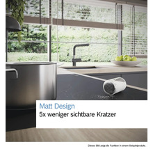 Helle, moderne Küche mit matter Induktionskochplatte, Edelstahltopf und Salz. Text: Matt Design, fünf mal weniger sichtbare Kratzer.
