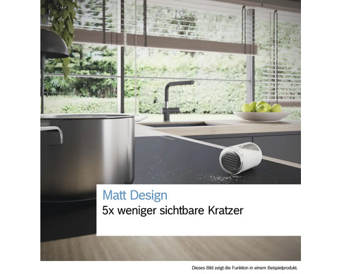 Helle, moderne Küche mit matter Induktionskochplatte, Edelstahltopf und Salz. Text: Matt Design, fünf mal weniger sichtbare Kratzer.