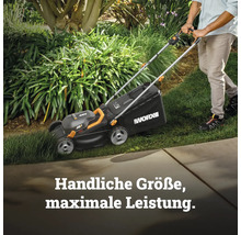 Eine Person schiebt einen schwarzen WORX 40 Volt Akku-Rasenmäher über eine grüne Rasenfläche in einem hellen Garten.