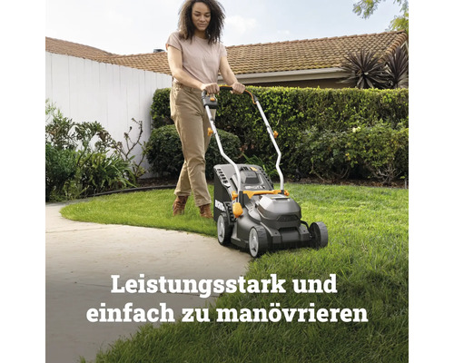 Eine Person mäht mit einem kompakten Rasenmäher eine Rasenfläche in einem sonnigen Garten.