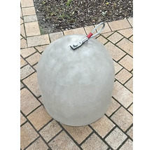Glockenförmiger Betonpoller mit Drahtseilschlaufe auf Pflastersteinen.