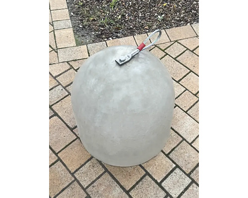 Glockenförmiger Betonpoller mit Drahtseilschlaufe auf Pflastersteinen.