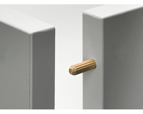 Nahaufnahme eines Holzdübels zur Verbindung von zwei weißen Möbelplatten.