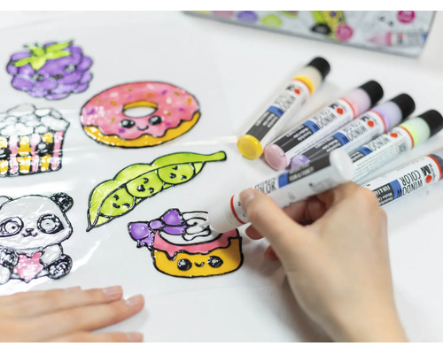 Eine Hand bemalt eine Folie mit bunten Window Color Fensterfarben, um niedliche Motive wie einen Donut und eine Erbse zu gestalten.