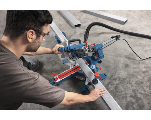 Handwerker benutzt eine Bosch Kapp- und Gehrungssäge zum Schneiden eines Metallprofils mit Gehörschutz und Schutzbrille.
